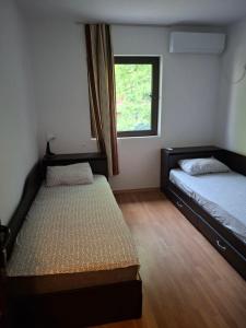 two beds in a room with a window at The Byala Escape, Private Villa with Bar & Hot Tub in Byala