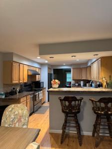 a kitchen with wooden cabinets and a table and chairs at Quiet Cozy Stay Spacious Home Near Beach & Shops in Hamden