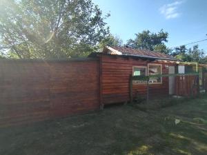 a wooden house with a fence next to it at Shambhala, eko selo Blatuša in Gvozd