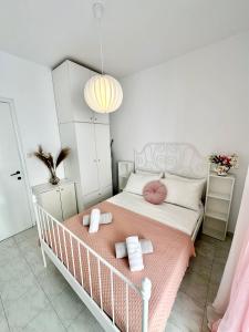 a small bedroom with a white bed with pink accents at Sea La Vie - Premium in Polychrono