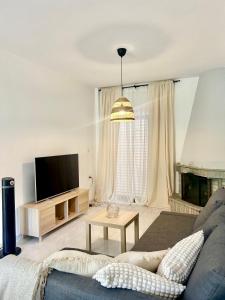 a living room with a couch and a tv at Sea La Vie - Premium in Polychrono