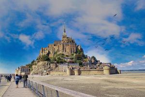 people walking on a pier in front of a castle at Parenthèse à la Maison de l'Ecrivain entre nature et petit déjeuner festin in Servon