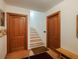 a hallway with two wooden doors and a staircase at Apartment Erika by Interhome in Canazei