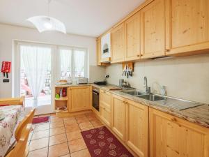 a kitchen with wooden cabinets and a sink at Apartment Erika by Interhome in Canazei +45 photos
