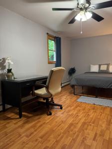 a bedroom with a desk and a bed and a ceiling fan at Quiet Cozy Stay Spacious Home Near Beach & Shops in Hamden