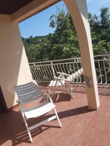 a chair sitting on a porch with a view at Kruce accommodation in Ulcinj +11 photos