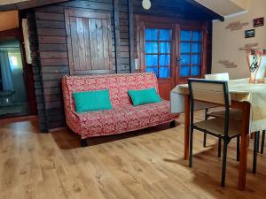 a living room with a red couch and a table at l'Oasi-Bungalow la Madonnina in Cardedu