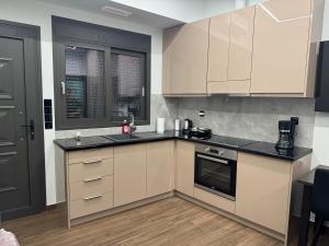 a kitchen with white cabinets and black counter tops at RAMhouse I in Arta