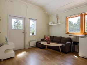 a living room with a couch and a table at Holiday Home Hölick Tallen 2 by Interhome in Hudiksvall