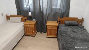 a bedroom with two beds and a window with curtains at The Byala Escape, Private Villa with Bar & Hot Tub in Byala