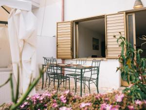 een tafel en stoelen op een patio met bloemen bij Apartment Rosa Dei Venti by Interhome in Santa Maria Navarrese +27 foto's
