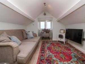 ビデフォードにあるSea Sanctuaryのソファと薄型テレビのあるリビングルーム