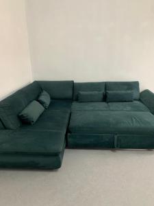 a green couch sitting in a living room at Volver Apartment in Margherita di Savoia
