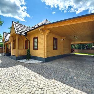 a yellow house with a brick driveway at Euro Resort in Chynadiyovo