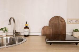 a kitchen with a sink and a bottle of wine at Arc de San Martí in Alghero +14 photos