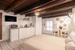 a living room with a bed and a kitchen at Arc de San Martí in Alghero