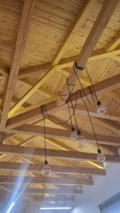 tre luci di vetro appese a un soffitto di legno di Φιλόξενο σπίτι στο Βόλο a Volos