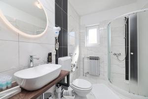a bathroom with a sink and a toilet and a mirror at Villa Anton in Sukošan