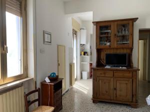 a living room with a television on a wooden cabinet at Tra Fiori e Antichità in Cerchiara