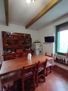 a dining room with a wooden table and a kitchen at Casa Sole Luna in Torre del Greco +21 photos