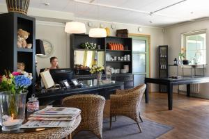 a woman sitting at a desk in a room at Maude´s Hotel Enskede Stockholm in Stockholm