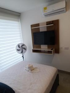 Estrene en Santa Marta vía Barranquilla a 10 minutos aeropuerto, acceso y vista al mar في سانتا مارتا: غرفة بسرير مع مروحة وتلفزيون