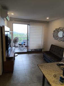 Estrene en Santa Marta vía Barranquilla a 10 minutos aeropuerto, acceso y vista al mar في سانتا مارتا: غرفة معيشة مع أريكة وتلفزيون