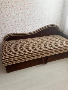 a wooden bed in a room with a wall at Vienibas prospekts in Jūrmala