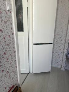 a white refrigerator in a room next to a door at Vienibas prospekts in Jūrmala
