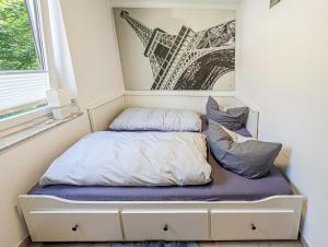 a bed in a room with a picture of the eiffel tower at H-Lodges - TOP City-Appartments in Essen in Essen