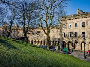 Un gran edificio con césped delante. en The Crows Nest, en Buxton