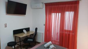 a bedroom with a desk and a red curtain at SpoonLand in Néa Koútali