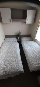 two beds in a small room at Hayling Island Holiday Park Holiday Home Sleeps 4 in South Hayling +15 photos