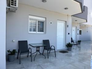 a table and chairs in a room with a white wall at CARISSA SUITES a in Afantou