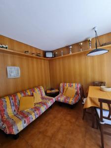 a living room with a couch and a table at Artesina - ski in & ski out - vista sulle Alpi e camino in Sella della Turra