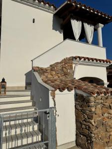 a white house with stairs and a gate at CasaNica - Elegant independent apartment in Torpè