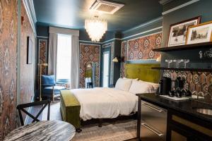 a bedroom with a bed and a desk in a room at The Gas Lamp Hotel in Philadelphia