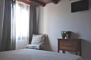 1 dormitorio con 1 cama, 1 silla y 1 ventana en La Medusa, en San Teodoro