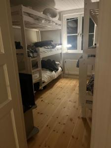 a room with white bunk beds and a wooden floor at Swedish idyll, alp around the corner! in Tallåsen