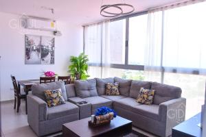 una sala de estar con un sofá y una mesa en Volcano Views Apartment, en San Salvador