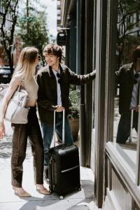 a man and woman looking in a store window with a suitcase at The Gas Lamp Hotel in Philadelphia