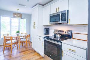 a kitchen with white cabinets and a table with chairs at Lazy Lagoon in Kiawah Island