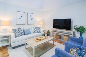 a living room with a couch and a tv at Lazy Lagoon in Kiawah Island