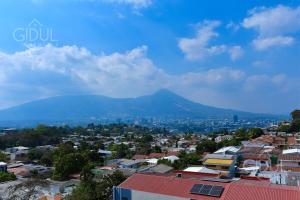 Una vista de una ciudad con una montaña al fondo. en Volcano Views Apartment, en San Salvador