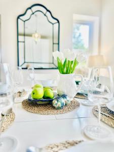 a table with a plate of limes and a vase of flowers at Cobblers Walk - Luxury Country Getaway 