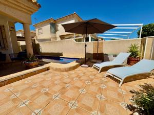 patio z 2 krzesłami i parasolem w obiekcie Casa Sol, Relax y Mar - a 5 min de la playa - Torre de la Horadada w mieście La Horadada