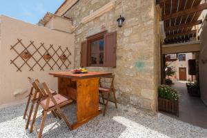 a wooden table and chairs on a patio at The old town Neighbourhood in Rhodes Town