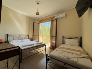 two beds in a room with a window at Pandesia Apartments in Argassi +7 photos