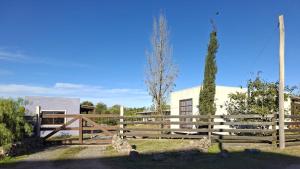 a wooden fence in front of a building at HABITACIONES ALUC, se reserva solo con seña in Chuy