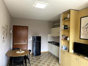 a small kitchen with a table and a refrigerator at Appartamento Paganini Modena in Modena